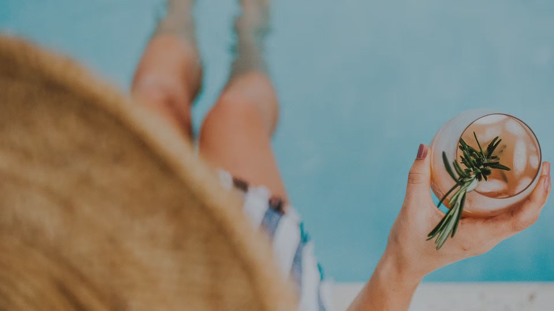 woman on pool edge with drink in hand